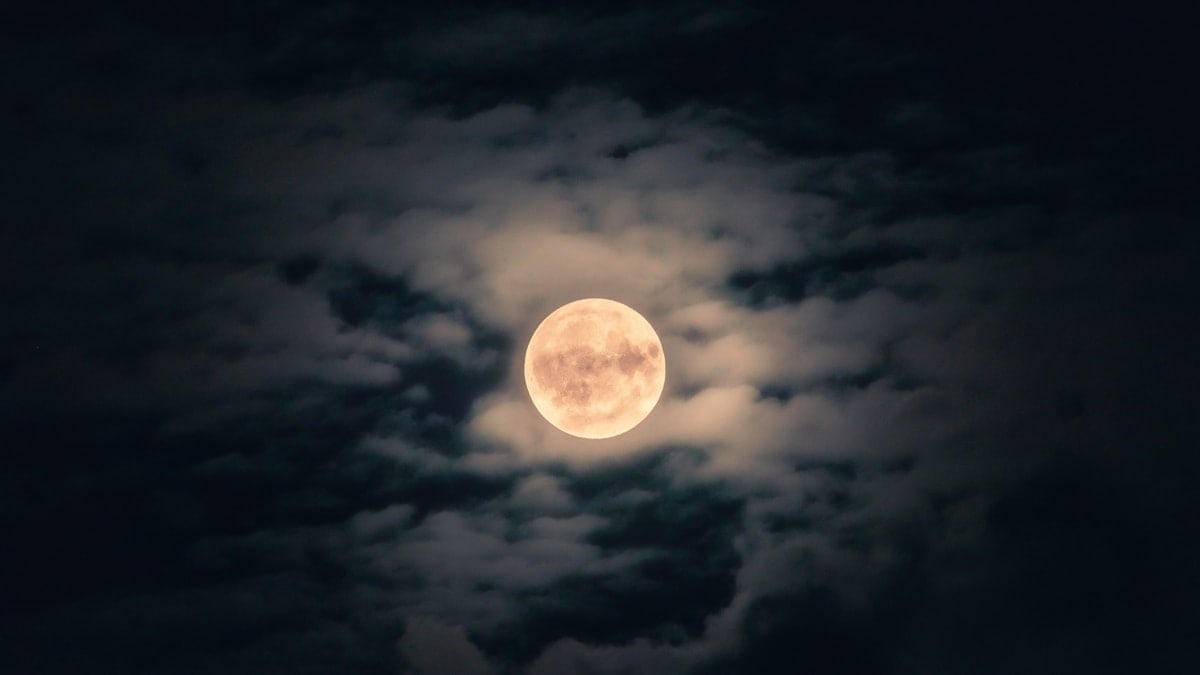 A full moon in a cloudy night sky
